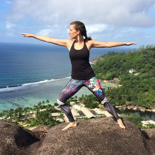 Keen employee doing a yoga pose, against a tropical background