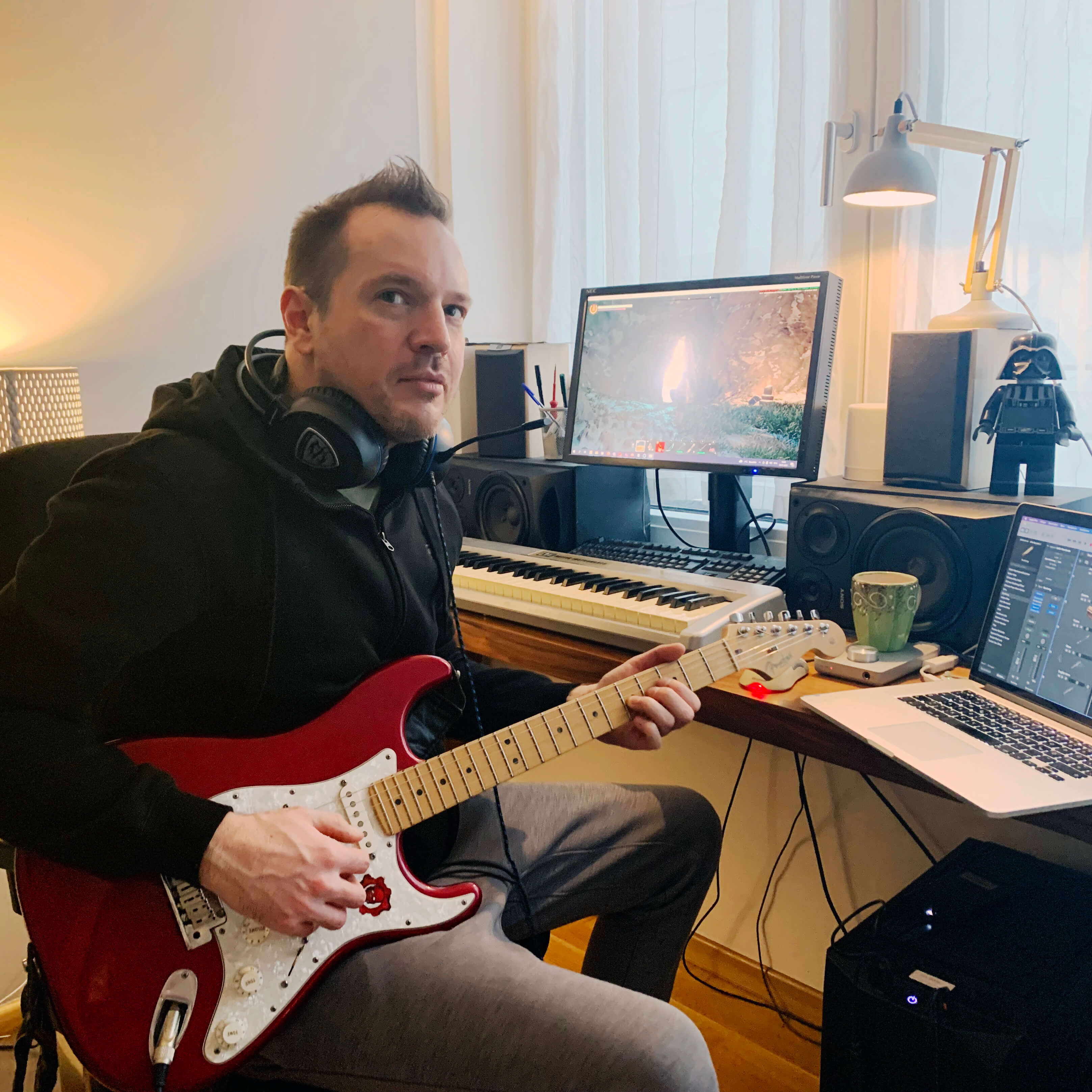 Keen employee sitting playing a guitar
