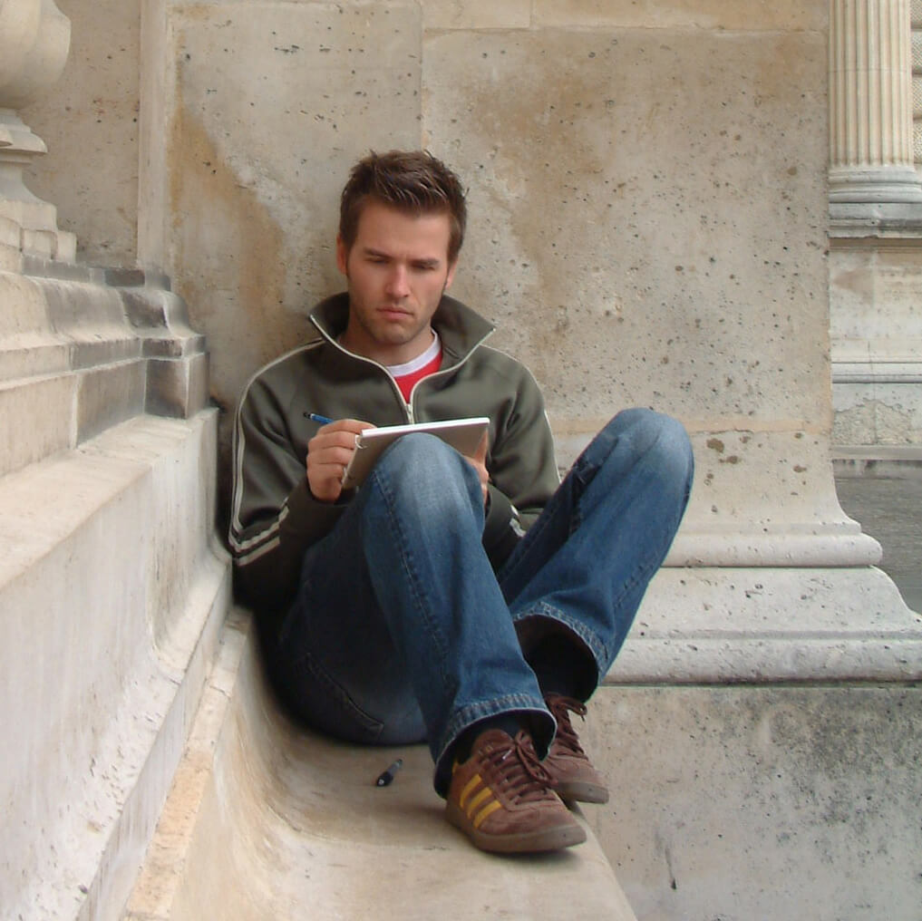 Keen employee sitting on some stone steps reading